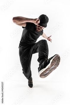 a man jumping in the air while wearing a black shirt and hat with his hands out