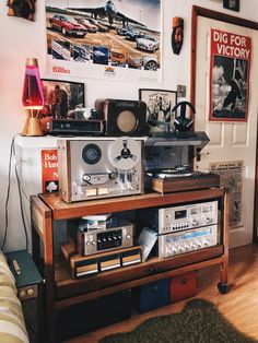 there is a radio and other electronics on the table in this room with pictures above it