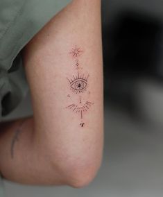 a woman's leg with an eye and stars tattoo on her left calf area