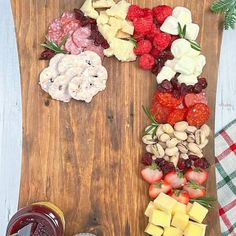 a wooden cutting board topped with fruit and veggies