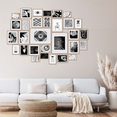 a white couch sitting in front of a wall with pictures on it's side