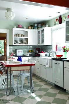 an image of a kitchen with white cabinets and green flooring in the color scheme