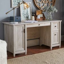 a wooden desk with two drawers and a clock on the wall in front of it