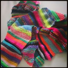 multicolored crocheted sweaters laid out on top of each other