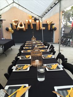 a table set up for a family celebration with balloons in the shape of a birdcage