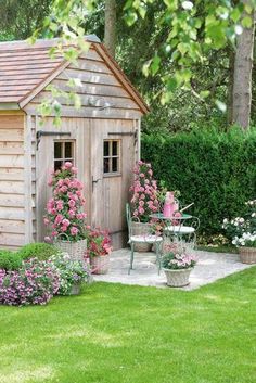 a garden shed with flowers around it