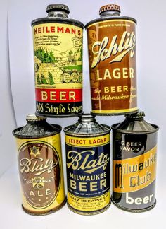 four different types of beer canisters sitting next to each other on a white surface