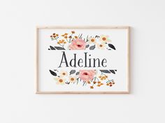 an art print with the word adeline surrounded by flowers and leaves on a white wall