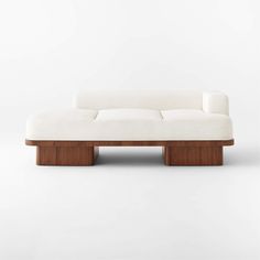 a white couch sitting on top of a wooden frame