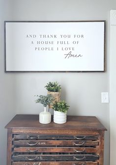 a wooden dresser with two vases and a sign above it that says, and thank you for a house full of people i love them