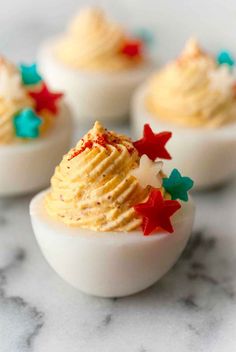 deviled eggs decorated with red, white and blue sprinkles on a marble surface