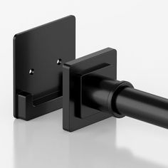 a black wall mounted toilet paper dispenser