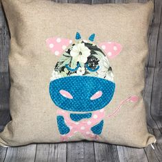 a pillow with a cow wearing a bow tie and flowers on it's head