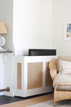 a living room with wicker furniture and a flat screen tv on top of a cabinet