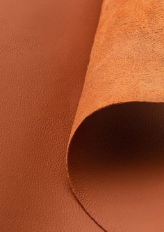 a close up view of a brown leather textured surface with the end cut out