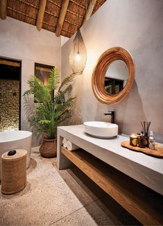 a bathroom with two sinks and a large mirror on the wall next to a potted plant