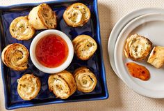 small appetizers with dipping sauce on a blue platter next to a white plate