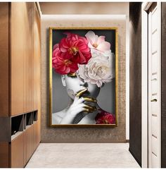 a woman's face with flowers in her hair is framed on the wall above a hallway