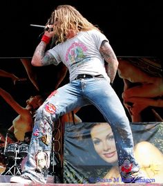 a man with long hair standing on stage