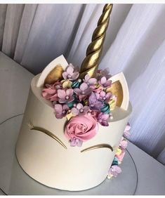 a white cake decorated with flowers and a gold horn