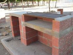 an outdoor bbq grill made out of red bricks