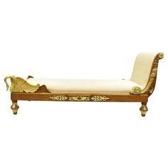 an antique style chaise lounge with gold trimmings and carvings on the back