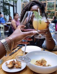 a woman holding up a wine glass in front of her face