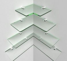 four glass shelves stacked on top of each other in the shape of a christmas tree