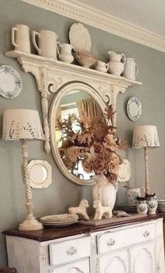 a room with a dresser, mirror and vase filled with flowers on top of it