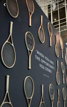 there are many tennis rackets on display in the building's exhibit area,