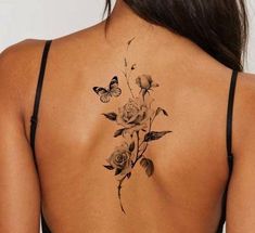 a woman's back tattoo with roses and butterflies