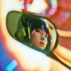 a woman's reflection in the side view mirror of a car