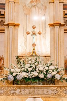 the altar is adorned with white flowers and greenery