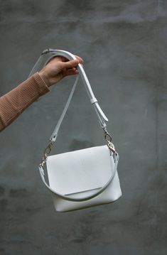 If you need a white minimalist leather handbag, so this mini one will fall into your heart. You can be sure that you will want more than one such crossbody bag in other colors and sizes. This white handbag is a great choice for a Christmas gift or for another occasion! HIGH QUALITY LEATHER The bag is made of high quality genuine leather. The leather is soft and pleasant to use. The structure and relief of the leather is very natural. The design will look perfectly with any style of clothing. Thi White Leather Handbag, White Top Handle Shoulder Bag With Smooth Grain, Minimalist Smooth Grain Crossbody Bag, White Smooth Grain Top Handle Shoulder Bag, Minimalist White Satchel Shoulder Bag, Modern White Satchel With Mobile Phone Bag, Chic White Shoulder Bag With Smooth Grain, White Minimalist Satchel Bag, Minimalist White Satchel Bag