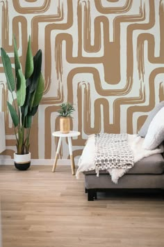 a living room with a couch, table and potted plant in front of the wall