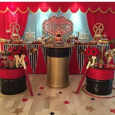 a circus themed birthday party with red and black decorations, gold accents and stars on the floor