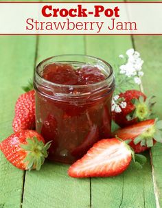 crock pot strawberry jam in a mason jar with strawberries on the side and text overlay