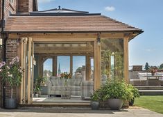 an outdoor living area with couches and potted plants