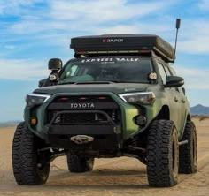 the toyota truck is parked in the middle of the desert with its roof rack on