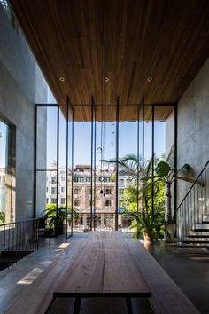 a wooden table sitting in the middle of a room with glass walls on both sides