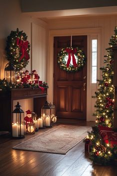 christmas wreaths and candles are on the floor in front of a door with lights