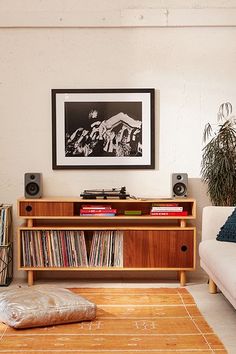 an image of a living room with music equipment on the table and pictures above it