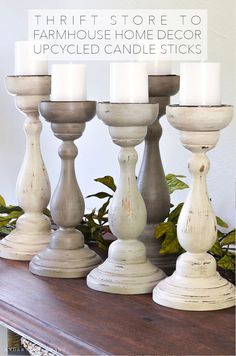 three white candles sitting on top of a wooden table