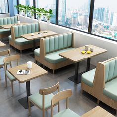 an empty restaurant with wooden tables and green booths in front of large windows overlooking the city