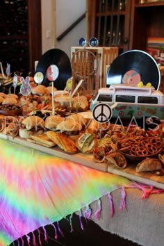 a table topped with lots of food covered in rainbow dyes and peace signs on top of it