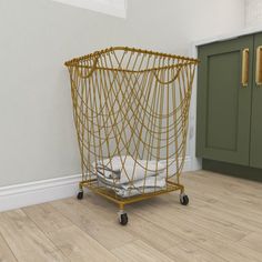 a wire basket sitting on top of a hard wood floor next to a green cabinet