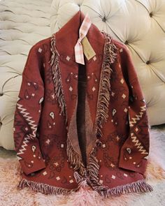 The softest knit base pairs with a western paisley print, blanket fringe & an easy long fit. Cozy long fit with an open front & soft fringe fold over collar. Color: Red rock, cream & brown Acrylic/poly blend Hand wash cold Model is a size 8 wearing a medium. Small Medium Large Bust 42 44 46 Waist 42 44 46 Hips 44 46 48 Length 32 32 32 Bust, waist, and hip measurements are a total circumference. Length is measured from the top of the shirt to the hem. Measurements are an estimate. Bohemian Jacquard Knit Outerwear For Fall, Western Paisley, Blanket Fringe, Western Sweaters, Fringe Blanket, Soft Fringe, Thrift Inspo, Brown Acrylic, Blanket Sweater