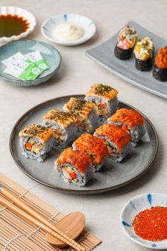 sushi is served on a plate with chopsticks next to it and other dishes