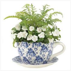 a blue and white cup with flowers in it