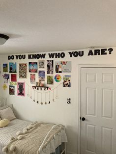 a bedroom with white walls and pictures on the wall